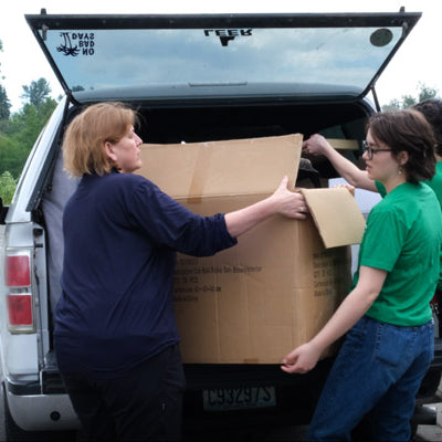 FurHaven employees offloading donations to Whatcom Humane Society from a car
